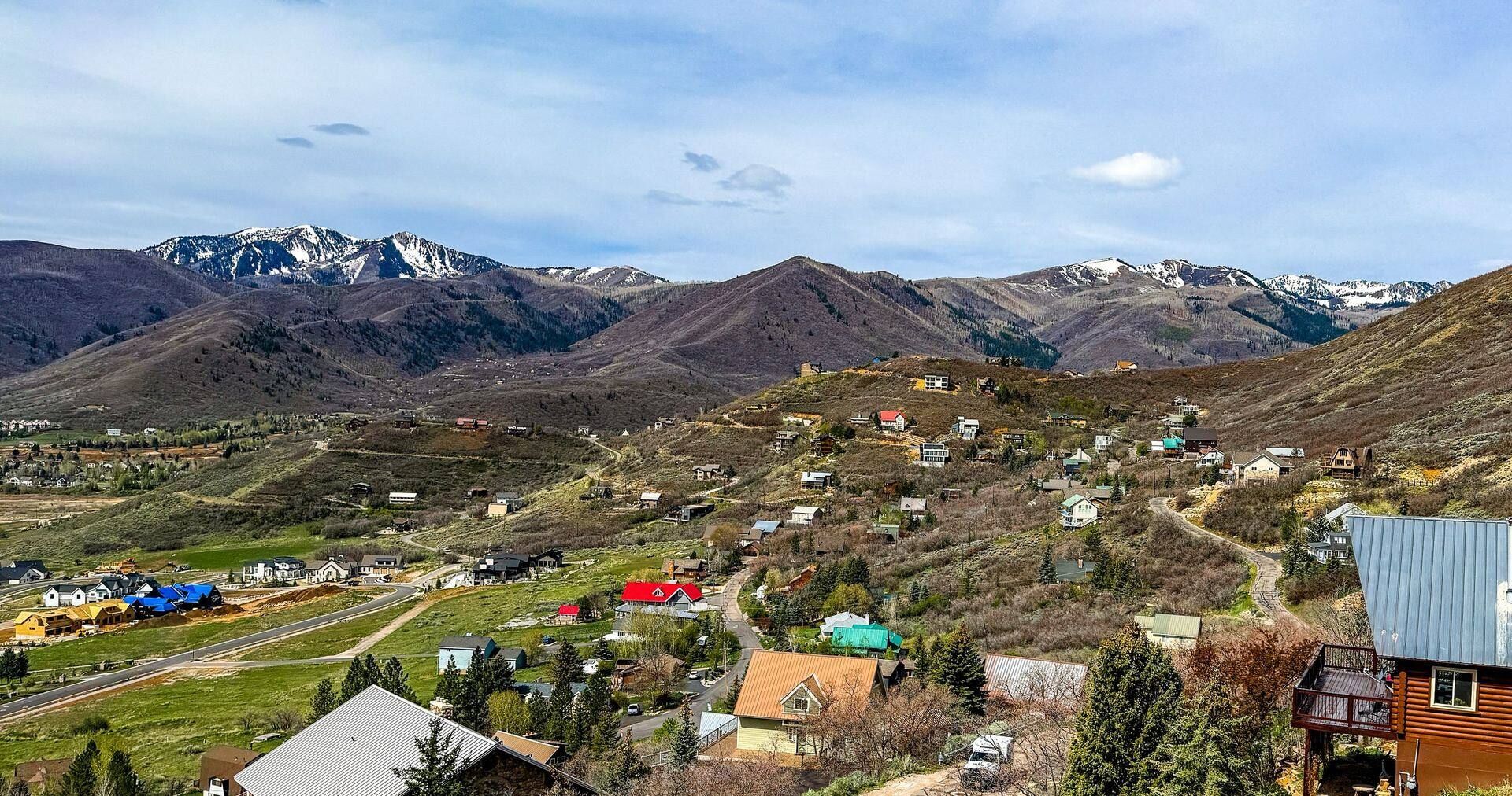 Interlaken hillside community in Midway Utah with custom homes stepping up the bench and snow-capped Wasatch Range in the background