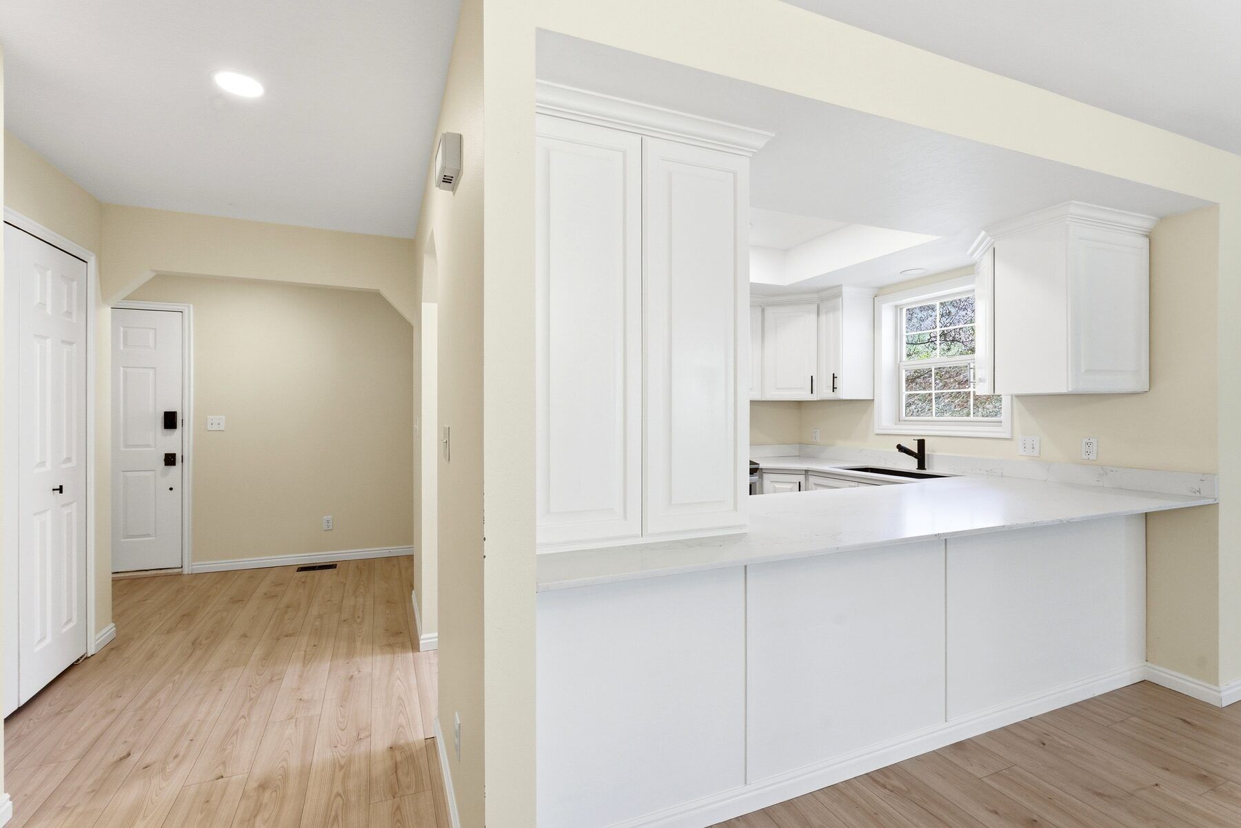 Kitchen with breakfast bar open to living area in remodeled Midway condo