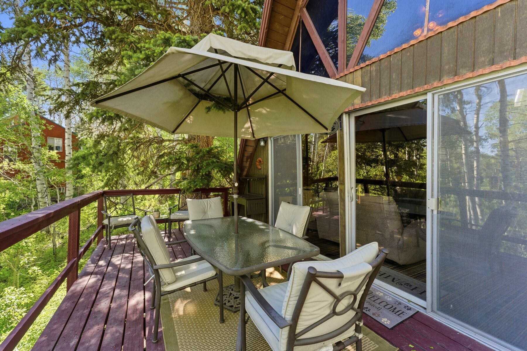 Private back deck with dining table set among the trees at a Heber City cabin