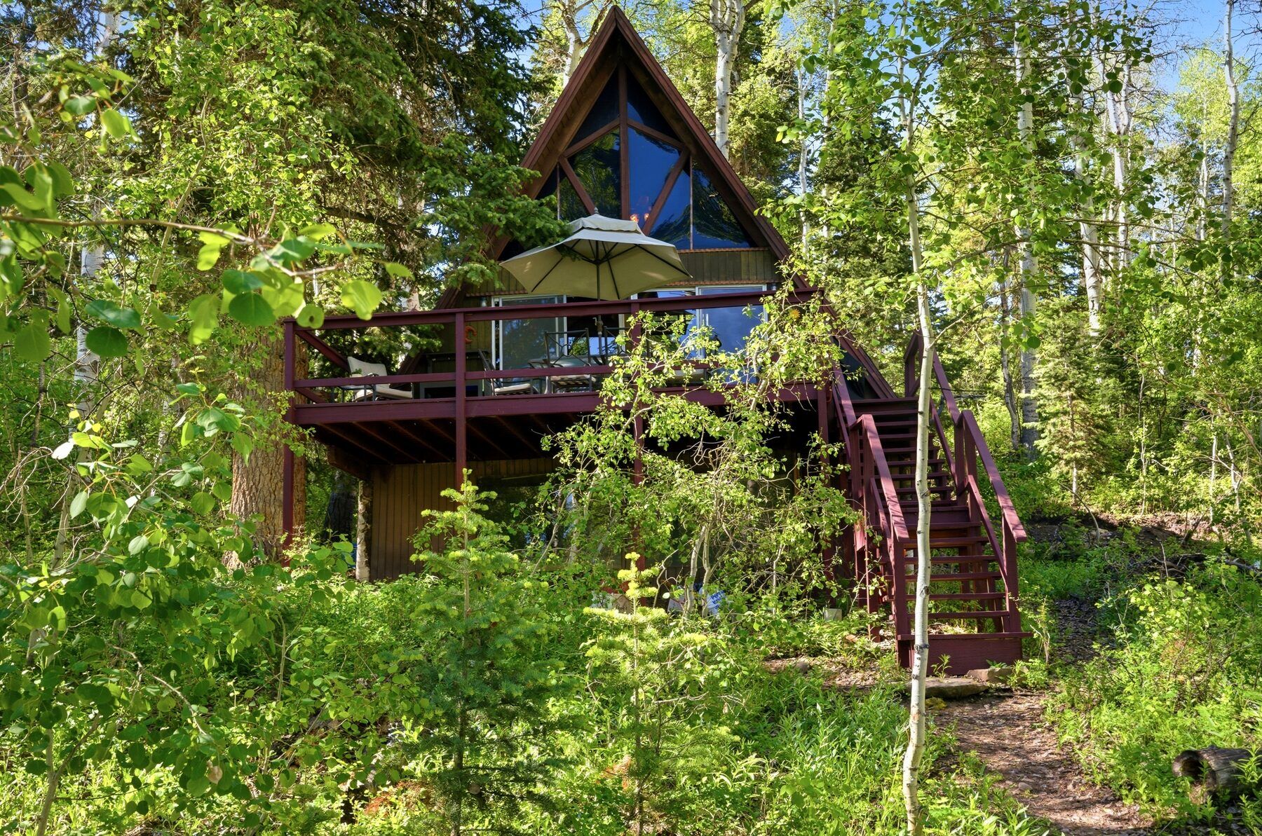 A-frame cabin profile among aspen trees in Timber Lakes Heber City