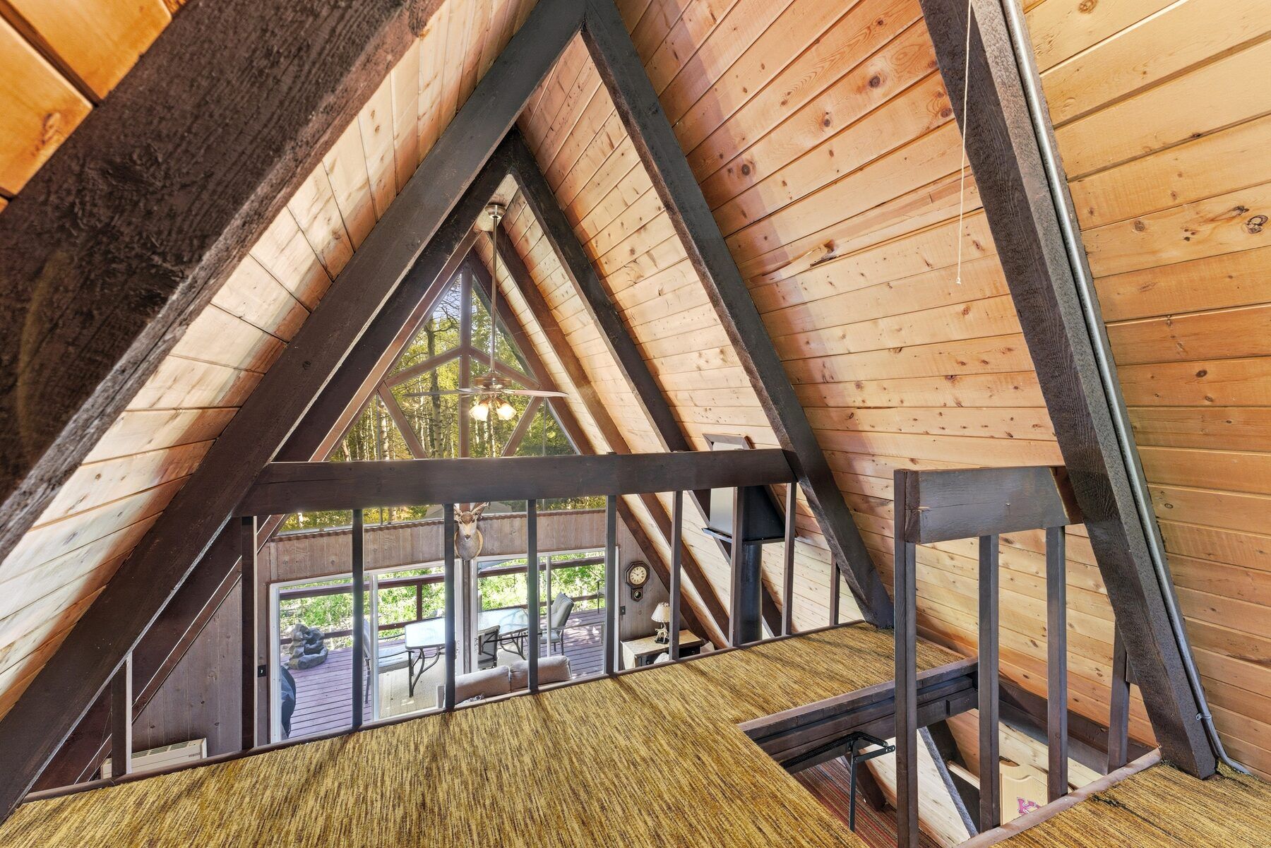 Loft overlooking the vaulted great room and forest windows in Timber Lakes A-frame cabin